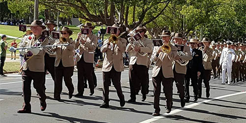 Harlaxton RSL Brass Band playing while marching down the street
